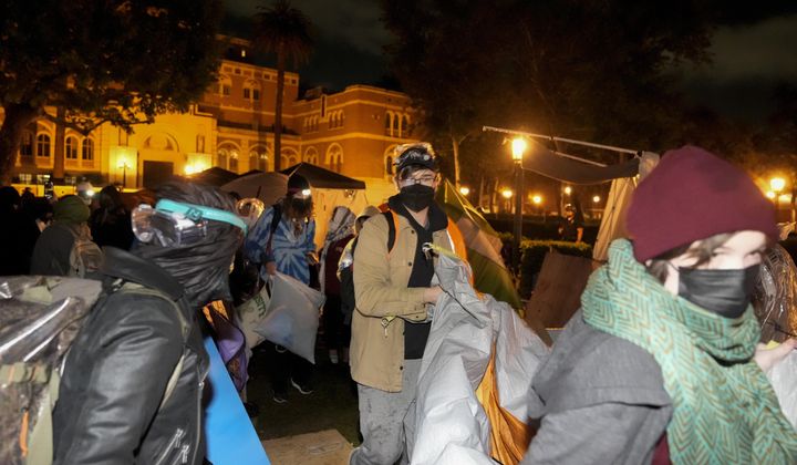 Pro-Palestinian demonstrators remove belongings from an encampment after police arrived on the campus at the University of Southern California Sunday, May 5, 2024, in Los Angeles. (AP Photo/Ryan Sun)