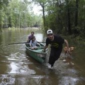 Alvaro Trevino pulls a canoe with Jennifer Tellez and Ailyn, 8, after they checked on their home on Sunday, May 5, 2024, in Spendora, Texas. The family has lived on the property in a rental trailer for two years. &quot;It&#x27;s really bad,&quot; said Tellez, who says they stayed dry during the most recent flooding in February. (Elizabeth Conley/Houston Chronicle via AP)