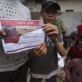 Palestinians hold leaflets dropped by Israeli planes calling on them to evacuate ahead of an Israeli military operation in Rafah, southern Gaza Strip, Monday, May 6, 2024. The order affects tens of thousands of people and could signal a broader invasion of Rafah, which Israel has identified as Hamas&#x27; last major stronghold after seven months of war. (AP Photo/Ismael Abu Dayyah)