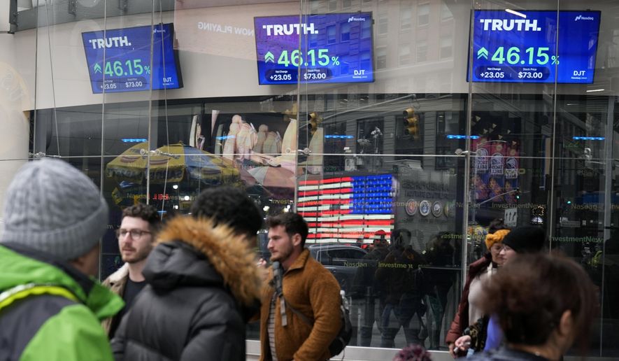 Pedestrians walk past the Nasdaq building as the stock price of Trump Media & Technology Group Corp. is displayed on screens, March 26, 2024, in New York. On Friday, May 3, Trump Media and Technology Group, the owner of social networking site Truth Social, fired BF Borgers, an auditor that federal regulators recently charged with “massive fraud.” (AP Photo/Frank Franklin II, File)