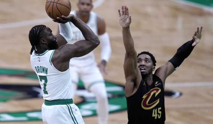Boston Celtics guard Jaylen Brown (7) shoots as Cleveland Cavaliers&#x27; Donovan Mitchell defends during the first half of Game 1 of an NBA basketball second-round playoff series Tuesday, May 7, 2024, in Boston. (AP Photo/Charles Krupa)