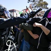 A protester is hit with a baton by a police officer at UC San Diego, May 6, 2024, in San Diego. As pro-Palestinian demonstrations escalate on college campuses around the country, critics of President Joe Biden’s handling of the Israel-Hamas war suggest this summer’s Democratic National Convention could be marred by protests and scenes of chaos that undermine his reelection. It raises the specter of a replay of 1968’s Democratic convention in Chicago, where a violent police crackdown created indelible scenes of chaos. (AP Photo/Denis Poroy, File)