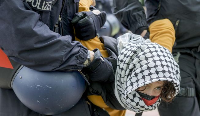 A woman is carried away by police officers during a pro-Palestinians demonstration by the group &quot;Student Coalition Berlin&quot; in the theater courtyard of the &#x27;Freie Universität Berlin&#x27; university in Berlin, Germany, Tuesday, May 7, 2024. Pro-Palestinian activists occupied a courtyard of the Free University in Berlin on Tuesday. (AP Photo/Markus Schreiber)