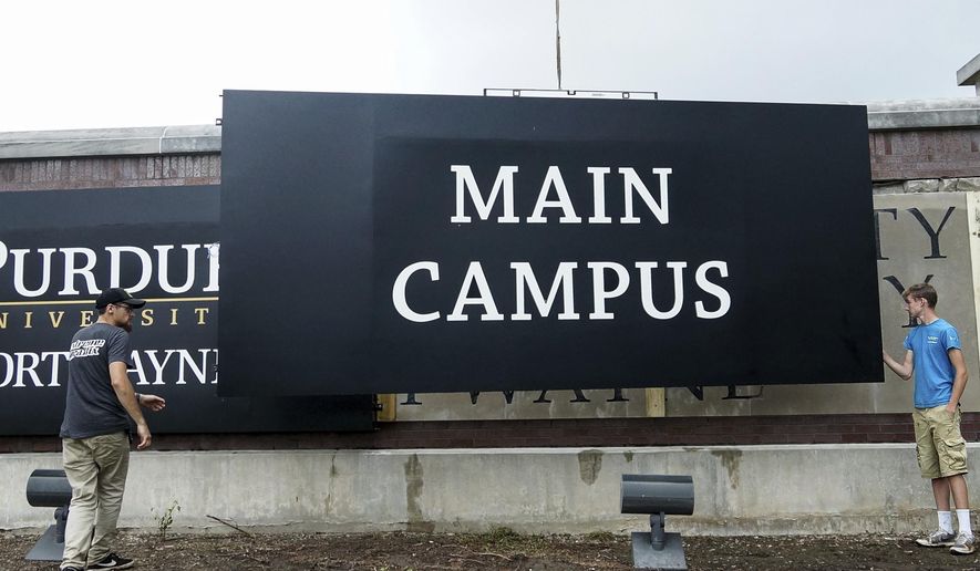 Workers install a Purdue University Fort Wayne sign adjacent to Coliseum Boulevard in Fort Wayne, Ind., Aug. 21, 2018. (Mike Moore/The Journal-Gazette via AP) ** FILE **