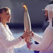 French Paralympic athlete Nantenin Keïta, left, passes the Olympic torch to French rap artist Jul during the torch arrival ceremony in Marseille, southern France, Wednesday May 8, 2024. After leaving Marseille, a vast relay route is undertaken before the torch odyssey ends on July 27 in Paris. The Paris 2024 Olympic Games will run from July 26 to Aug.11, 2024. Keita is visually impaired and won a gold medal during the 2016 Olympics in Rio de Janeiro. (Ludovic Marin, Pool via AP)