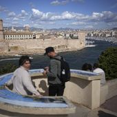 People stand in the gardens of the Palais du Pharo, overlooking the old port, the day ahead of the arrival of the Olympic flame, in Marseille, southern France, Tuesday, May 7, 2024. The Olympic torch will finally enter France when it reaches the southern seaport of Marseille on Wednesday. (AP Photo/Laurent Cipriani)