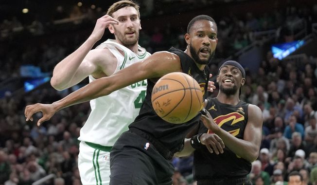 Cleveland Cavaliers forward Evan Mobley, center, and guard Caris LeVert, right, and Boston Celtics center Luke Kornet watch the ball get away during the first half of Game 2 of an NBA basketball second-round playoff series Thursday, May 9, 2024, in Boston. (AP Photo/Steven Senne)