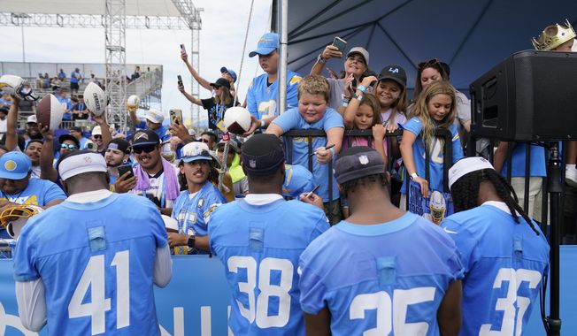 Los Angeles Chargers safety Raheem Layne (41), cornerback Cam Brown (38), cornerback Amechi Uzodinma (35) and cornerback Ja&#x27;Sir Taylor (36) sign autographs for fans during the NFL football team&#x27;s training camp, Saturday, July 29, 2023, in Costa Mesa, Calif. For at least one year, Southern California will be a prime spot for NFL training camps. With the Costa Mesa City Council unanimously approving a deal with the Las Vegas Raiders, five teams, the Raiders, Chargers, Rams, Saints and Cowboys, will be holding their practices within a 105-mile radius in late July and early August. (AP Photo/Ashley Landis, File)