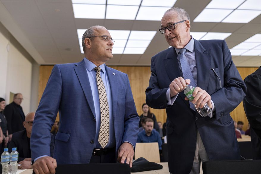Deputy federal spokesperson for Alternative for Germany party (AfD) Peter Boehringer, left, and assessor on the AfD's federal executive board Roman Reusch stand in the courtroom before the verdict in the appeal proceedings in the dispute over the classification of the AfD by the Federal Office for the Protection of the Constitution at the Higher Administrative Court for the state of North Rhine-Westphalia, in Muenster, Germany, Monday May 13, 2024. The administrative court in Muenster ruled in favor of the BfW intelligence agency on Monday, upholding a 2022 decision by a lower court in Cologne. Alternative for Germany, or AfD, has rejected the designation strongly. The party could still seek to appeal the verdict at a federal court. (Guido Kirchner/dpa/dpa via AP)