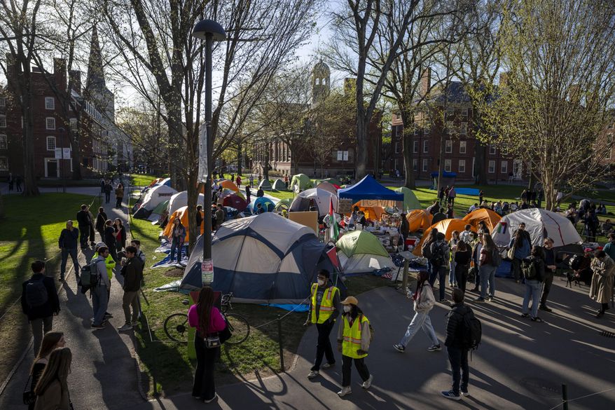 Students protesting against the war in Gaza and passersby walking through Harvard Yard are seen at an encampment at Harvard University in Cambridge, Mass., on April 25, 2024. (AP Photo/Ben Curtis, File)