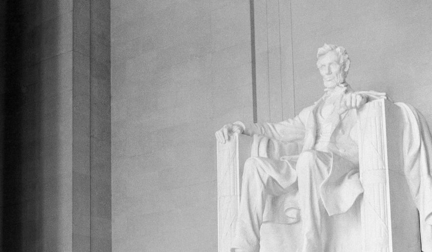 The statue of Abraham Lincoln dwarfs seven Black students from Central High School in Little Rock, Ark., as one of the students, Terrance Roberts, places a wreath at the statue's base during a visit to the Lincoln Memorial, Aug. 26, 1958, in Washington. (AP Photo/William J. Smith)