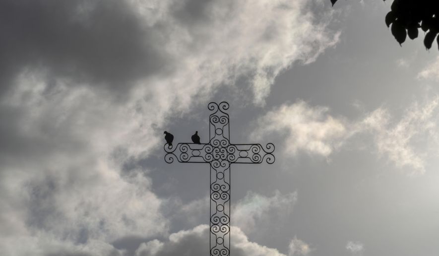 Doves perch on a church cross during a Good Friday procession in Havana, Cuba, Friday, March 29, 2024. More than 60% of Cuba’s 11 million people are baptized Catholic, according to the church. But experts estimate that as many, or more, also follow Afro-Cuban traditions such as Santeria that intermingle with Catholicism. (AP Photo/Ramon Espinosa)