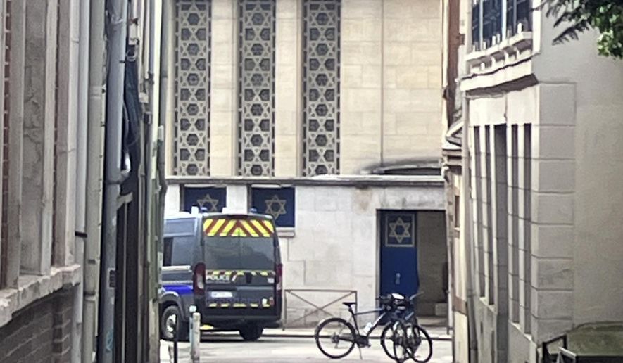 A police car is parked in front of the synagogue in Rouen, France, Friday, May 17, 2024. French police have shot and killed a man armed with a knife and a metal bar who is suspected of having set fire to a synagogue in the Normandy city of Rouen. (AP Photo/Oleg Cetinic)