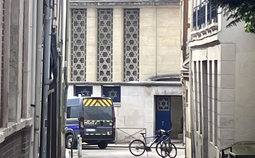 A police car is parked in front of the synagogue in Rouen, France, Friday, May 17, 2024. French police have shot and killed a man armed with a knife and a metal bar who is suspected of having set fire to a synagogue in the Normandy city of Rouen. (AP Photo/Oleg Cetinic)