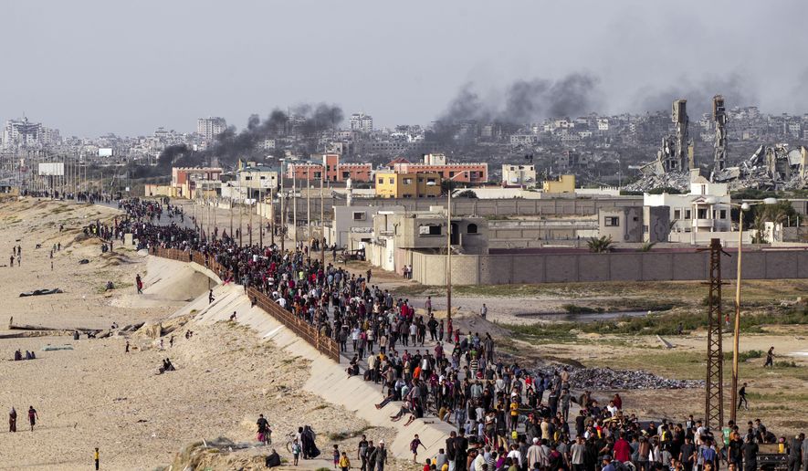 Palestinians are waiting for aid trucks to cross in central Gaza Strip on Sunday, May 19, 2024. (AP Photo/Abdel Kareem Hana)