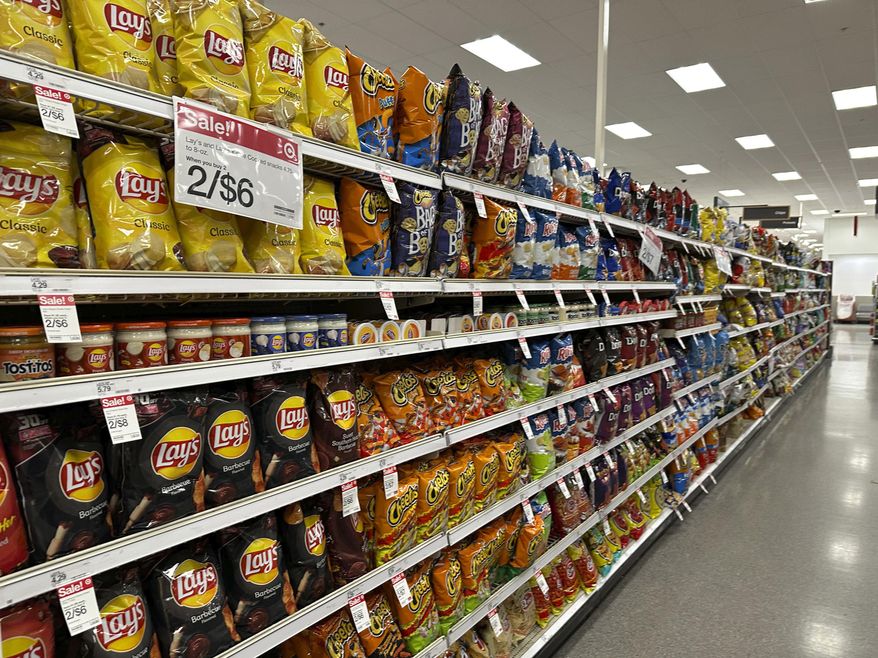 Sale signs hang on the long display of snacks at a Target store Oct. 4, 2023, in Sheridan, Colo. Target plans on cutting prices on thousands of consumer basics this summer, goods ranging from diapers to milk, with more Americans paying closer attention to their spending as inflation cuts into household budgets.(AP Photo/David Zalubowski, File)