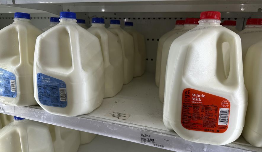 Gallons of reduced fat and whole milk sit on display in a refrigerated case in a Target store April 29, 2024, in Littleton, Colo. Target plans on cutting prices on thousands of consumer basics this summer, goods ranging from diapers to milk, with more Americans paying closer attention to their spending as inflation cuts into household budgets. (AP Photo/David Zalubowski, File)