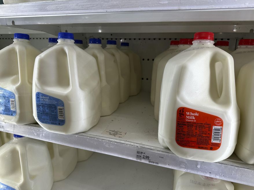 Gallons of reduced fat and whole milk sit on display in a refrigerated case in a Target store April 29, 2024, in Littleton, Colo. Target plans on cutting prices on thousands of consumer basics this summer, goods ranging from diapers to milk, with more Americans paying closer attention to their spending as inflation cuts into household budgets. (AP Photo/David Zalubowski, File)