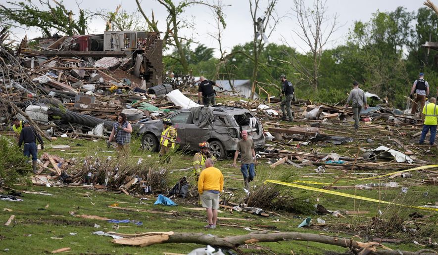 Workers search through the remains of tornado-damaged homes, Tuesday, May 21, 2024, in Greenfield, Iowa. (AP Photo/Charlie Neibergall)
