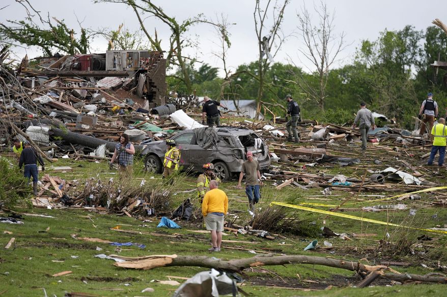 Workers search through the remains of tornado-damaged homes, Tuesday, May 21, 2024, in Greenfield, Iowa. (AP Photo/Charlie Neibergall)