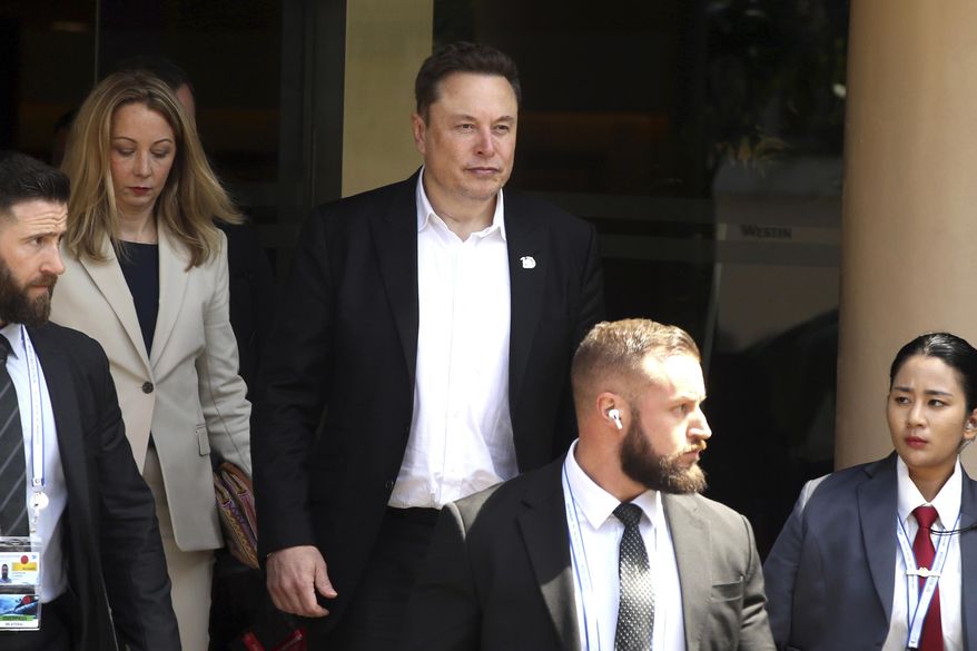 Elon Musk, center, arrives for the 10th World Water Forum in Nusa Dua, Bali, Indonesia on Monday, May 20, 2024. A group of Tesla shareholders are asking investors to vote against a compensation package worth more than $40 billion for CEO Elon Musk, saying that it's not in the electric vehicle maker's best interest.(AP Photo/Firdia Lisnawati, File)