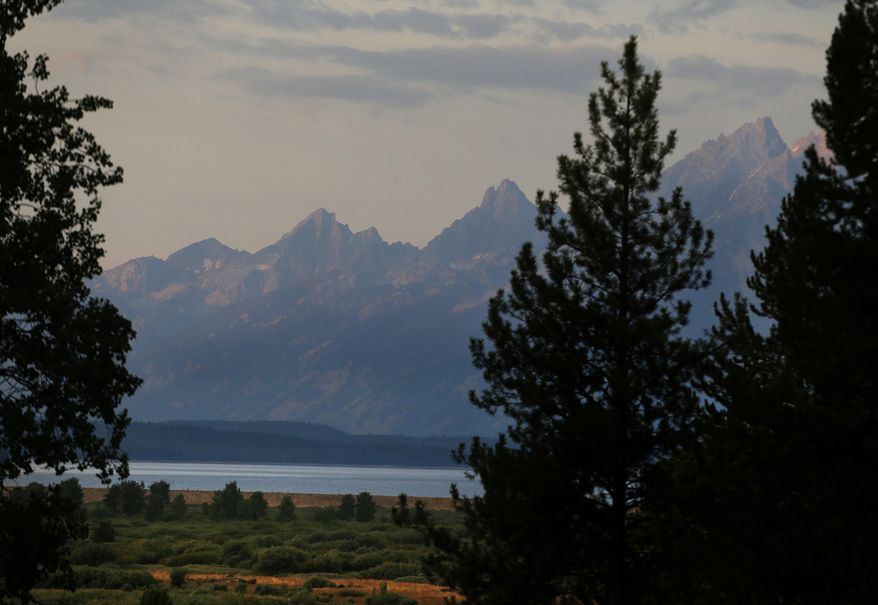 FILE - The morning sun illuminates the Grand Tetons at Grand Teton National Park, north of Jackson Hole, Wyo., Aug 26, 2016. A grizzly bear that attacked a hiker in Wyoming's Grand Teton National Park won't be captured or killed by wildlife authorities because it may have been trying to protect a cub, park officials said in a statement Tuesday, May 21, 2024. (AP Photo/Brennan Linsley, File)