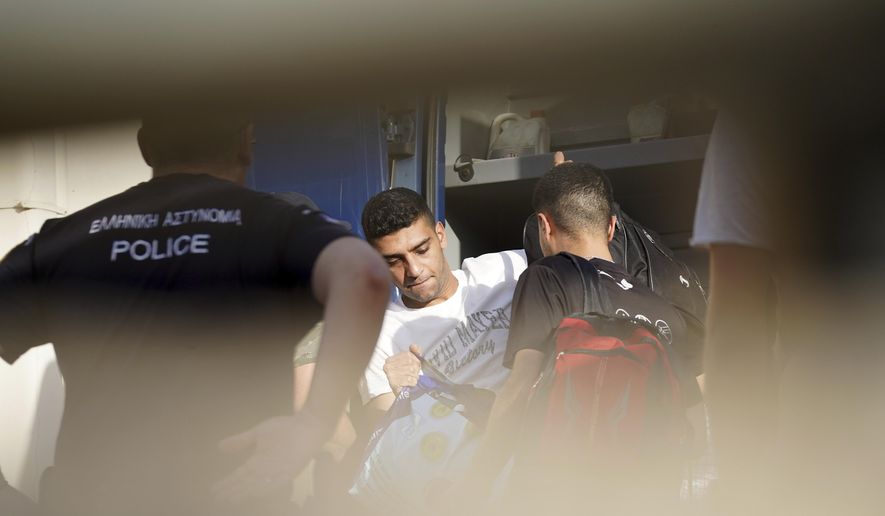 Egyptian shipwreck survivors enter a police station to be processed following their release from prison, in the town of Nafplio, about 136 kilometers (85 miles) southwest of Athens, Greece, Wednesday, May 22, 2024. A Greek court Monday dismissed a case against nine Egyptian defendants accused of causing a shipwreck off the southern coast of Greece last June that killed several hundred migrants travelling from Libya to Italy. The suspects had spent 11 months in pre-trial prison detention. (AP Photo/Elena Becatoros)