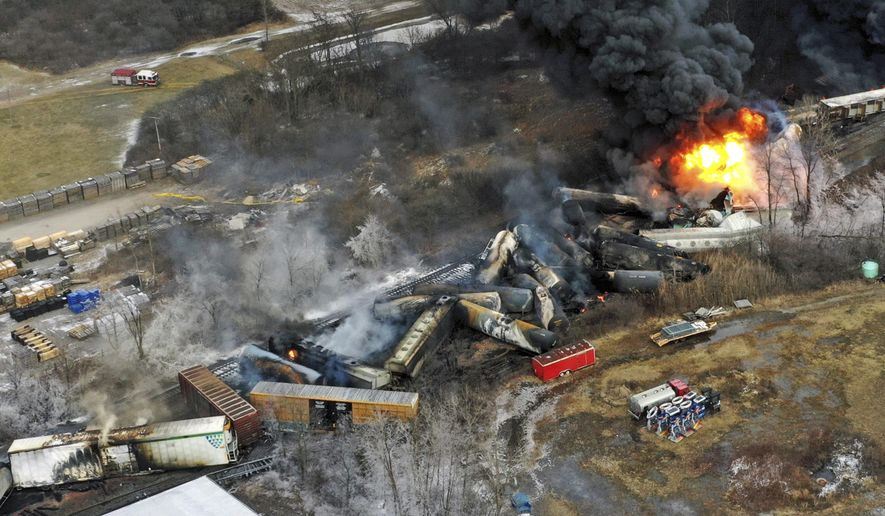FILE - Debris from a Norfolk Southern freight train lies scattered and burning along the tracks on Feb. 4, 2023, the day after it derailed in East Palestine, Ohio. A federal judge has signed off Tuesday, May 21, 2024, on the $600 million class action settlement over last year's disastrous Norfolk Southern derailment in eastern Ohio, but many people who live near East Palestine are still wondering how much they will end up with out of the deal. (AP Photo/Gene J. Puskar, File)