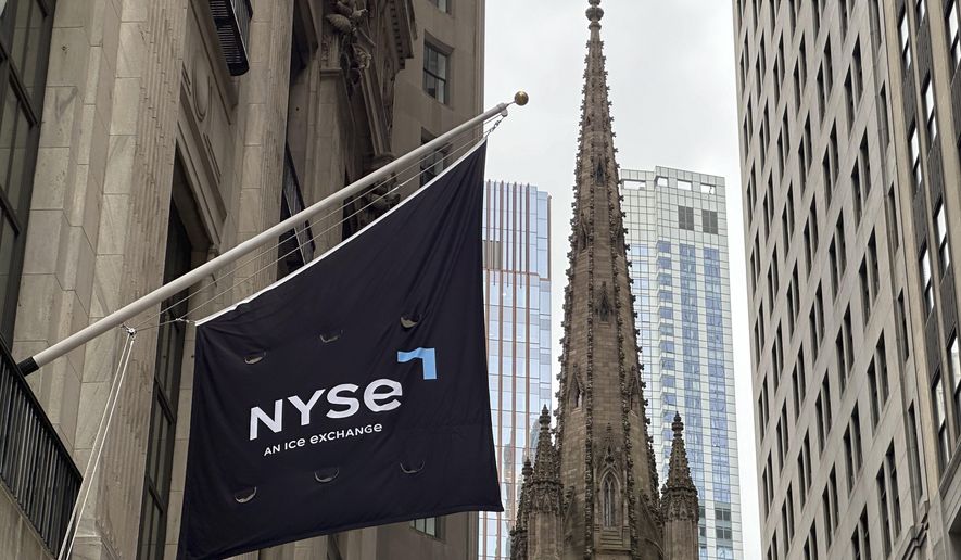 FILE - A flag hangs from the side of the New York Stock Exchange is on Thursday, May 16, 2024, in New York. Trinity Church appears in the background. (AP Photo/Peter Morgan, File)