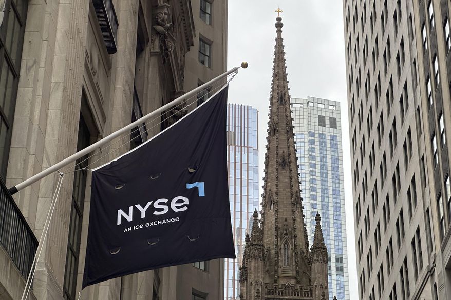 FILE - A flag hangs from the side of the New York Stock Exchange is on Thursday, May 16, 2024, in New York. Trinity Church appears in the background. (AP Photo/Peter Morgan, File)
