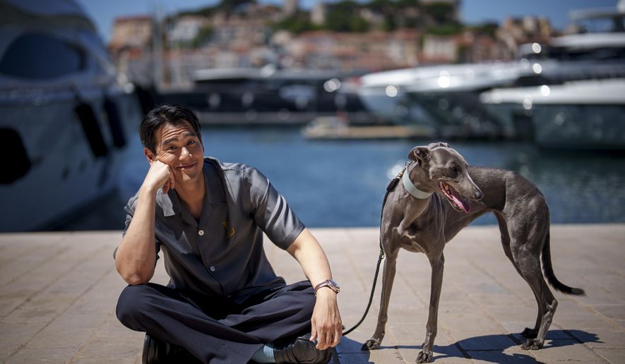 Eddie Peng poses with his dog Xin during an interview for the film 'Black Dog' at the 77th international film festival, Cannes, southern France, Tuesday, May 21, 2024. (Photo by Andreea Alexandru/Invision/AP)