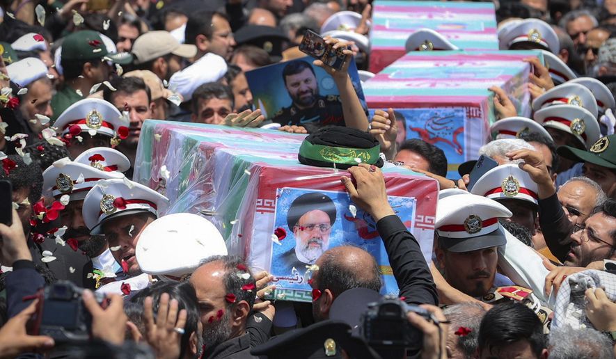 In this photo released by the Iranian Presidency Office, flag-draped coffins of the President Ebrahim Raisi and his companions who were killed in a helicopter crash on Sunday, during their funeral ceremony in the city of Mashhad, Iran, Thursday, May 23, 2024. Iran on Thursday prepared to inter its late president at the holiest site for Shiite Muslims in the Islamic Republic, a final sign of respect for a protégé of Iran's supreme leader killed in a helicopter crash earlier this week. (Iranian Presidency Office via AP)