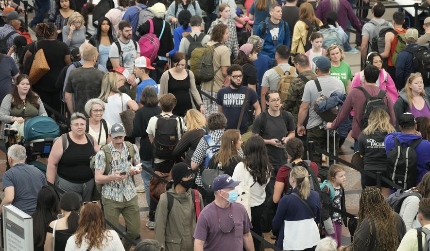 FILE - Travelers move through a security checkpoint in Denver International Airport ahead of the Memorial Day holiday on May 26, 2023, in Denver. A record number of Americans are expected to hit the pavement and the air over the 2024 Memorial Day weekend. (AP Photo/David Zalubowski, File)