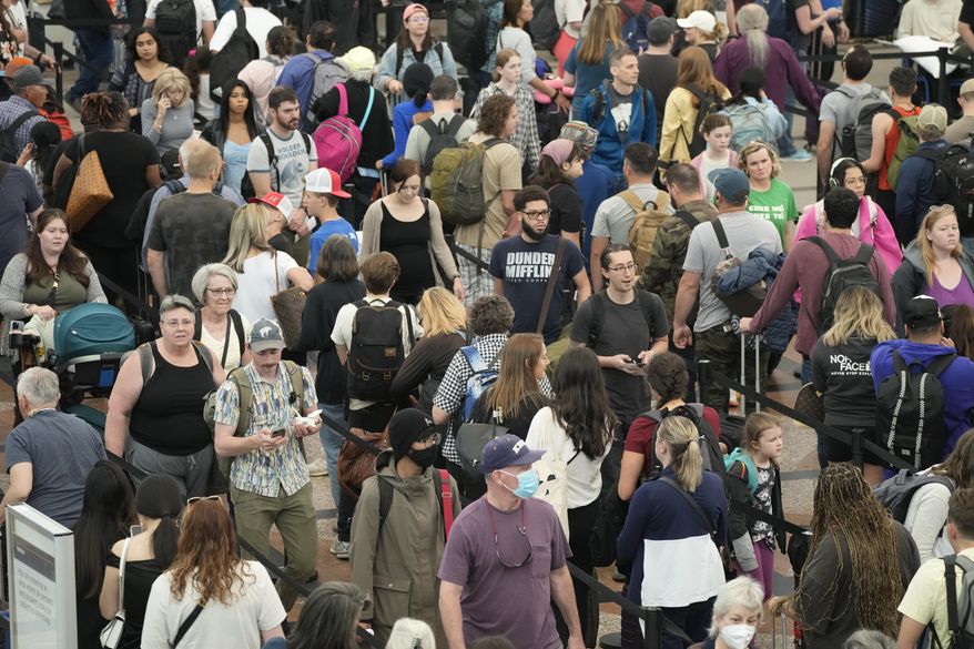FILE - Travelers move through a security checkpoint in Denver International Airport ahead of the Memorial Day holiday on May 26, 2023, in Denver. A record number of Americans are expected to hit the pavement and the air over the 2024 Memorial Day weekend. (AP Photo/David Zalubowski, File)