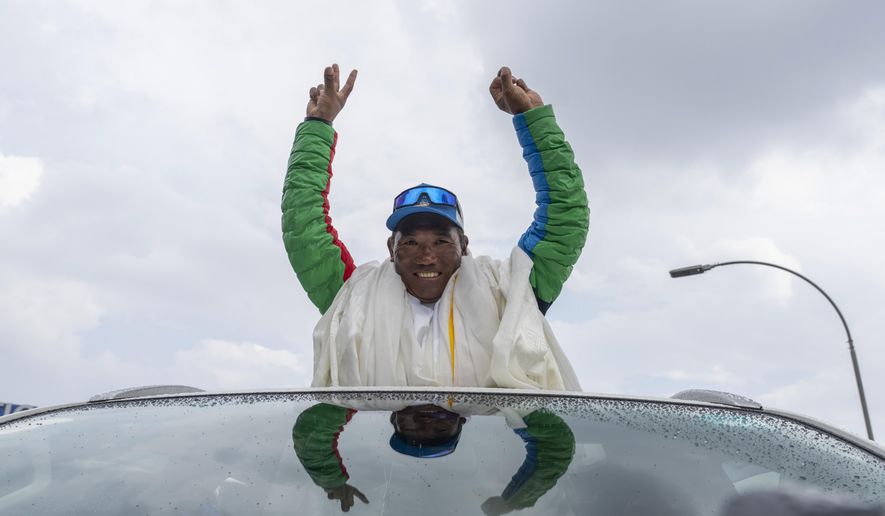Renowned Sherpa mountain guide Kami Rita returning from Mount Everest after his record 30th successful ascent, waves after he arrives at the airport in Kathmandu, Nepal, Friday, May 24, 2024. (AP Photo/Niranjan Shrestha)