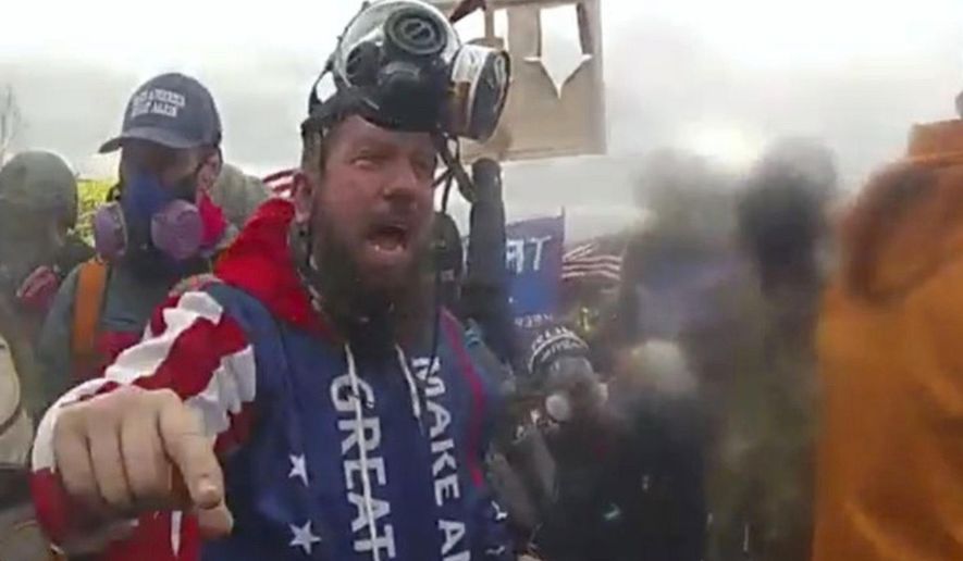 In this image from U.S. Capitol Police video, released and annotated by the Justice Department in the sentencing memorandum, Christopher Quaglin, appears on police body-worn camera footage at the U.S. Capitol on Jan. 6, 2021, in Washington. Quaglin, a New Jersey electrician who repeatedly attacked police officers during the siege at the U.S. Capitol has been sentenced to 12 years in prison. (Justice Department via AP)