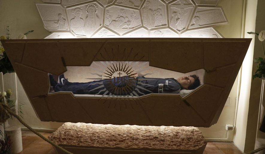 FILE - 15-year-old Carlo Acutis, an Italian boy who died in 2006 of leukemia, lies in state ahead of being beatified by Cardinal Agostino Vallini, in Assisi, Italy, on Oct. 10, 2020. Pope Francis has paved the way for the canonization of the first saint of the millennial generation on Thursday, attributing a second miracle to a 15-year-old Italian computer whiz who died of leukemia in 2006. Carlo Acutis, born on May 3, 1991, in London and then moved with his Italian parents to Milan as a child, was the youngest contemporary person to be beatified by Francis in Assisi in 2020. (AP Photo/Gregorio Borgia, File)