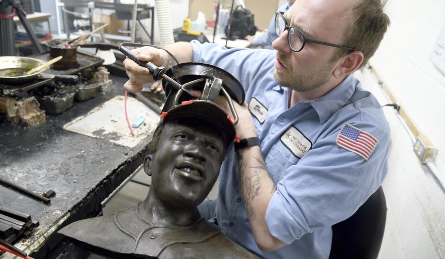 David Hobbs, an employee at Art Castings of Colorado, touches up a wax mold of Jackie Robinson's head in Loveland, Colo. on Wednesday, May 8, 2024. The original statue was cut off at the ankles and stolen from a park in Wichita, Kansas in January. The Colorado foundry cast that sculpture in 2019 and, luckily, still had the original plaster and rubber molds. (AP Photo/Thomas Peipert)