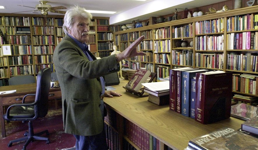 Schuyler Jones talks about the bookcases he built that line his library Monday, Feb. 6, 2006, in Wichita, Kansas. Jones, a globe-trotting American adventurer whose exploits drew comparisons to iconic movie character Indiana Jones, has died. He was 94. Jones' step-daughter, Cassandra Da'Luz Vieira-Manion, posted on her Facebook page that Jones died on May 17, 2024. (Dave Williams/The Wichita Eagle via AP)