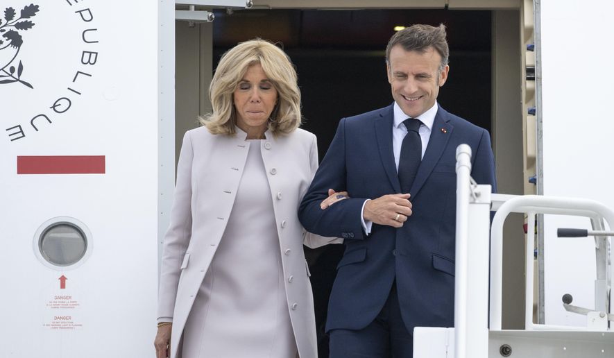 French President Emmanuel Macron and his wife Brigitte Macron arrive at the military section of BER Airport, in France, ahead of their three-day state visit to Germany, Sunday, May 26, 2024. (Christophe Gateau/dpa via AP)