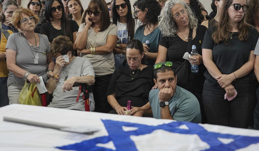 Mourners attend the funeral of Michel Nisenbaum, who was killed during Hamas' Oct. 7 attack and whose body was taken into Gaza, in Ashkelon, Israel, on Sunday, May 26, 2024. The Israeli military recovered Nisenbaum's remains, along with those of two other Israelis killed during the attack, in an operation in Gaza last week. (AP Photo/Tsafrir Abayov)