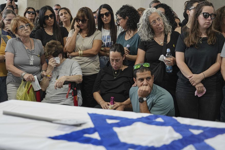Mourners attend the funeral of Michel Nisenbaum, who was killed during Hamas' Oct. 7 attack and whose body was taken into Gaza, in Ashkelon, Israel, on Sunday, May 26, 2024. The Israeli military recovered Nisenbaum's remains, along with those of two other Israelis killed during the attack, in an operation in Gaza last week. (AP Photo/Tsafrir Abayov)