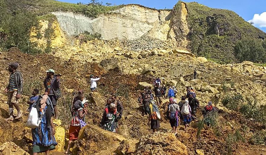 In this photo provided by the UNDP Papua New Guinea, villagers search through a landslide in Yambali village in the Highlands of Papua New Guinea, Sunday, May 26, 2024. The International Organization for Migration feared Sunday the death toll from a massive landslide is much worse than what authorities initially estimated. (Kafuri Yaro/UNDP Papua New Guinea via AP)