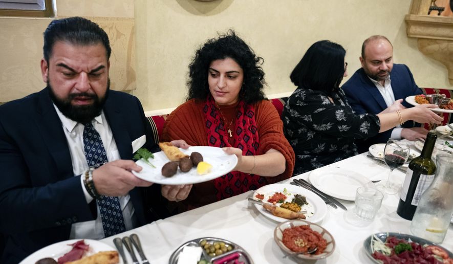 Sophia Armen, center passes a dish to Dr. Armond Aghakhanian and joined for lunch with other members of the Armenian-American Census Coalition, Suzie Abajian and former California Assembly Member Adrian Nazarian at the Carousel, a Lebanese-Armenian restaurant in Glendale, Calif. on Friday, May 17, 2024. For some race and ethnic groups, how the U.S. government categorizes them for crucial surveys and the once-a-decade census is still falling short. Hmong as well as Armenian, Arab American and Brazilian communities say they feel excluded or diminished when it comes to how they are counted in their own country. (AP Photo/Richard Vogel)
