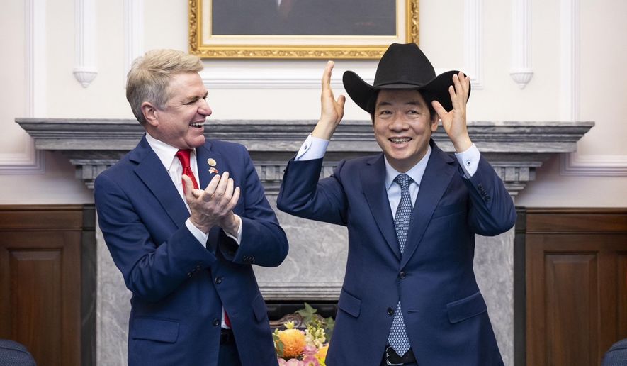 In this photo released by the Taiwan Presidential Office, Taiwan President Lai Ching-te, right, puts on a cowboy hat given by Rep. Michael McCaul, R-Texas during a meeting in Taipei, Taiwan, Monday, May 27, 2024. A U.S. congressional delegation met Taiwan's new leader on Monday in a show of support shortly after China held drills around the self-governing island in response to his inauguration speech. (Taiwan Presidential Office via AP)