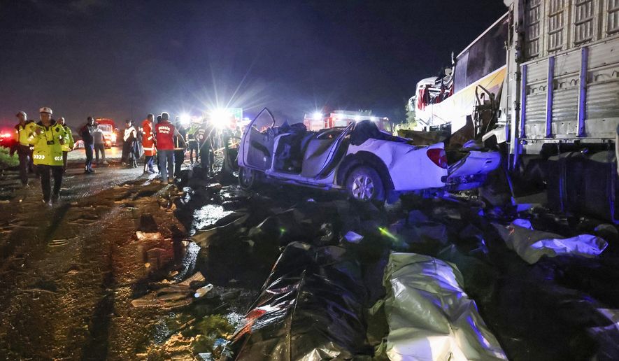 Emergency rescue teams and police officers work on the aftermath of a multi vehicle crash accident near Mersin, southern Turkey, Sunday, May 26, 2024. A passenger bus has crashed into vehicles on a highway in southern Turkey, killing at least 10 people and leaving 39 others injured. The accident occurred in the province of Mersin late on Sunday, when the bus veered into the opposite lane in heavy rain and crashed into two vehicles. (IHA via AP)