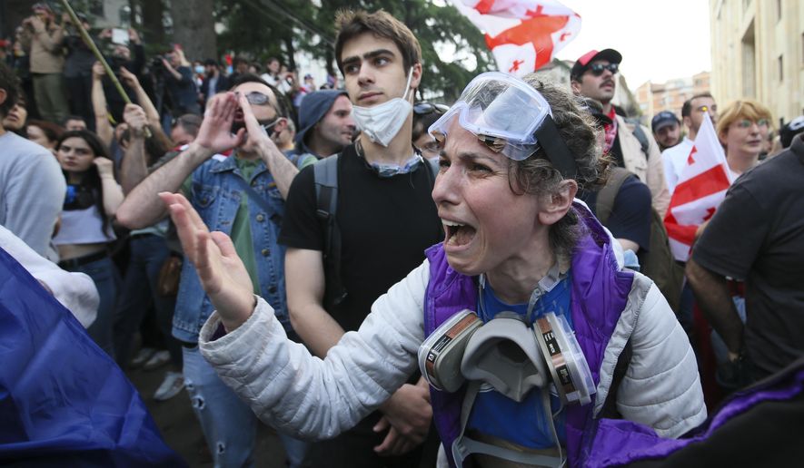A demonstrator argues with police officers during an opposition protest against the foreign influence bill at the Parliamentary building in Tbilisi, Georgia, Tuesday, May 28, 2024. The Georgian parliament has overridden a presidential veto of the "foreign agents" legislation that has fueled Western concerns and sparked massive protests for weeks. (AP Photo/Zurab Tsertsvadze)