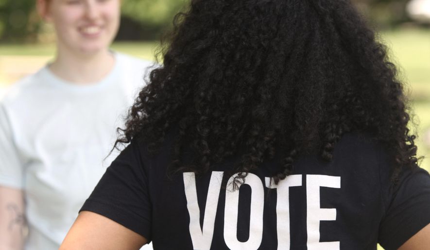 Anita Alexander, vice president for the Kansas group Loud Light, wears a T-shirt encouraging voting on the campus of Washburn University, Friday, May 18, 2024, in Topeka, Kan. Their group does voter registration drives on college campuses but has suspended that work while it challenges a state elections law that it says hampers registration drives. Laws passed in several Republican-controlled states are making it challenging for advocates to adapt as they try to register and educate potential voters with just months to go before the presidential election. (AP Photo/John Hanna)