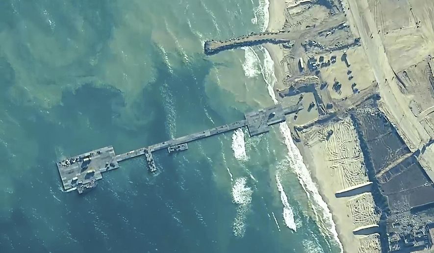 FILE - The image provided by U.S, Central Command, shows U.S. Army soldiers assigned to the 7th Transportation Brigade (Expeditionary), U.S. Navy sailors assigned to Amphibious Construction Battalion 1, and Israel Defense Forces placing the Trident Pier on the coast of Gaza Strip on May 16, 2024. A U.S. built temporary pier that had been used to deliver additional humanitarian aid into Gaza was damaged by rough seas and has temporarily suspended operations. That’s according to three U.S. officials who spoke to The Associated Press on Tuesday. (U.S. Central Command via AP)