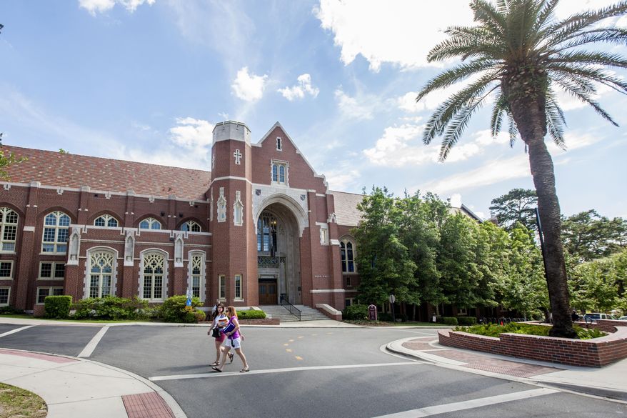 FILE - Students walk past the Dodd Hall on the campus of Florida State University in Tallahassee, Fla., Friday April 30, 2015. A University of Florida research employee and students have been implicated in an illegal, multi-million dollar scheme investigated by the Justice Department to fraudulently buy thousands of biochemical samples of dangerous drugs and toxins that were delivered to a campus laboratory then illicitly shipped to China over seven years. (AP Photo/Mark Wallheiser, file)